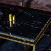 Rectangular coffee table on gold glossy frame, black top imitating marble, modern style, exclusive