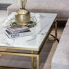 Rectangular coffee table on gold shiny frame, white top imitating marble, modern style, sophisticated